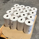 Pallet of white paper rolls in a warehouse setting